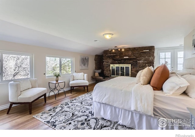 3786 Eldorado Springs Dr, Boulder, CO 80303 - bedroom with light wood-type flooring, baseboards, and a stone fireplace