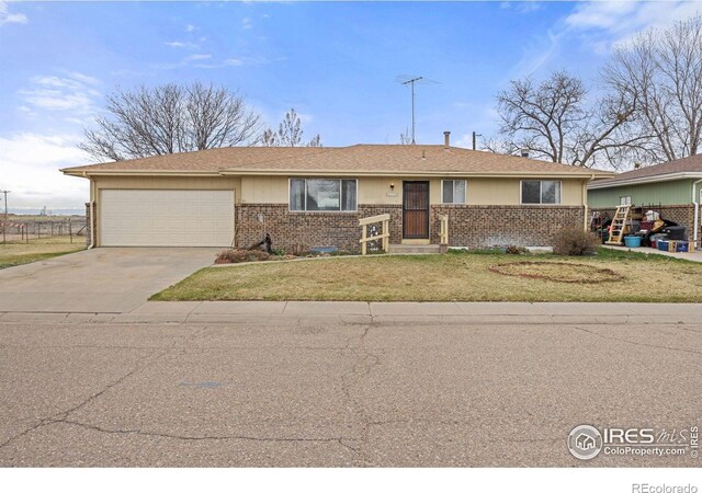 ranch-style house featuring an attached garage, concrete driveway, a front yard, and brick siding