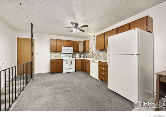 kitchen with a ceiling fan, light countertops, white appliances, and brown cabinetry
