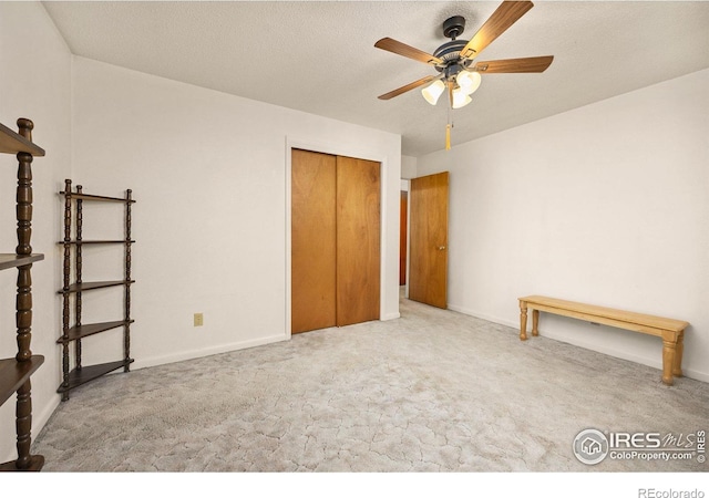 unfurnished bedroom with a closet, carpet, baseboards, and a textured ceiling