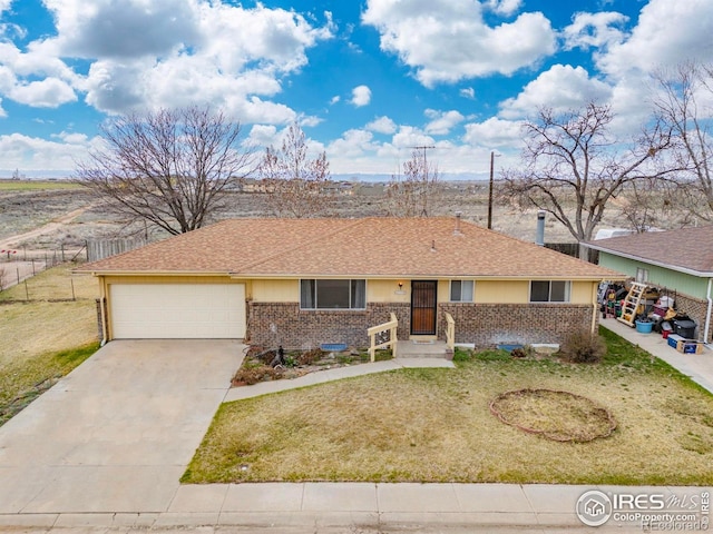 ranch-style house featuring concrete driveway, an attached garage, a front yard, brick siding, and fence