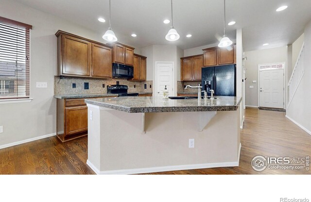 5543 Calgary St, Timnath, CO 80547 - kitchen featuring black appliances, a sink, brown cabinetry, tasteful backsplash, and recessed lighting