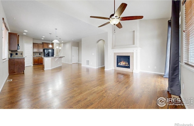 5543 Calgary St, Timnath, CO 80547 - unfurnished living room featuring a ceiling fan, dark wood-style floors, baseboards, recessed lighting, and a fireplace