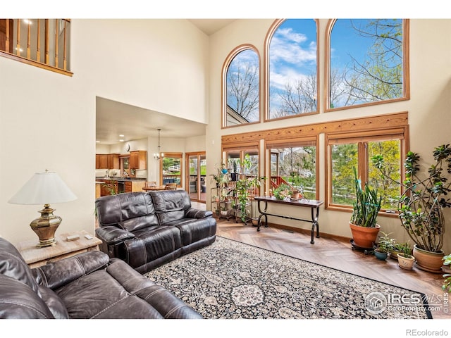 living room featuring baseboards, a wealth of natural light, and a towering ceiling