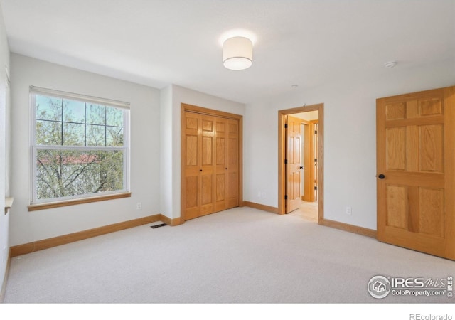 unfurnished bedroom with baseboards, a closet, visible vents, and carpet