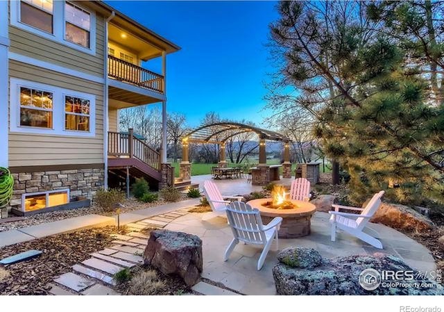 view of patio / terrace with a fire pit, a gazebo, stairs, and a balcony