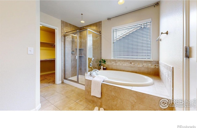 full bath featuring a spacious closet, tile patterned floors, a bath, and a stall shower