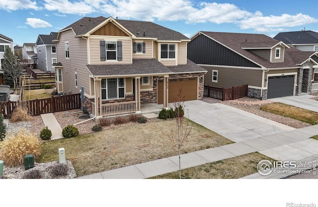 craftsman-style house with board and batten siding, a porch, fence, and concrete driveway