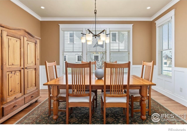 245 Spruce St, Louisville, CO 80027 - dining area with a chandelier, a wealth of natural light, a wainscoted wall, and wood finished floors