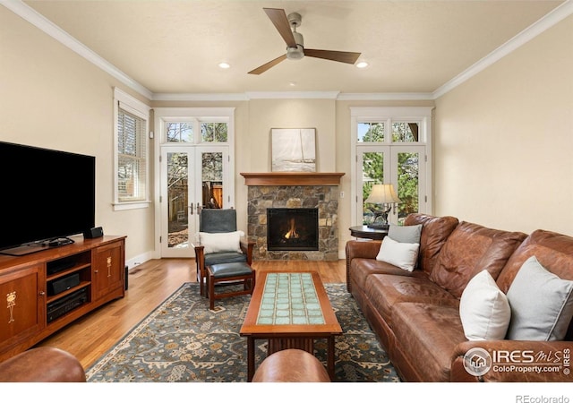 245 Spruce St, Louisville, CO 80027 - living area featuring light wood finished floors, a stone fireplace, ornamental molding, and ceiling fan