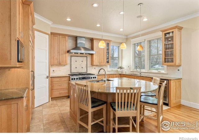 245 Spruce St, Louisville, CO 80027 - kitchen with wall chimney exhaust hood, stainless steel gas stovetop, a sink, a center island with sink, and decorative backsplash