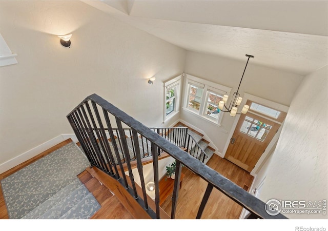 245 Spruce St, Louisville, CO 80027 - stairs with baseboards, vaulted ceiling, a chandelier, and wood finished floors