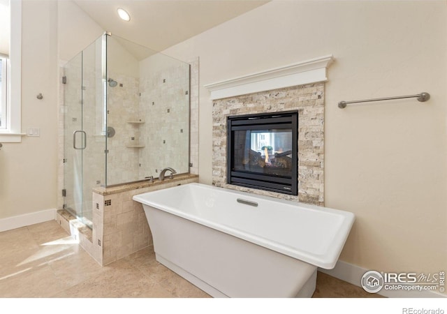 245 Spruce St, Louisville, CO 80027 - full bath featuring a soaking tub, a multi sided fireplace, a shower stall, lofted ceiling, and baseboards