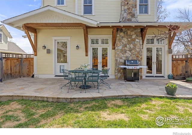 245 Spruce St, Louisville, CO 80027 - rear view of property featuring french doors, fence, stone siding, and a patio