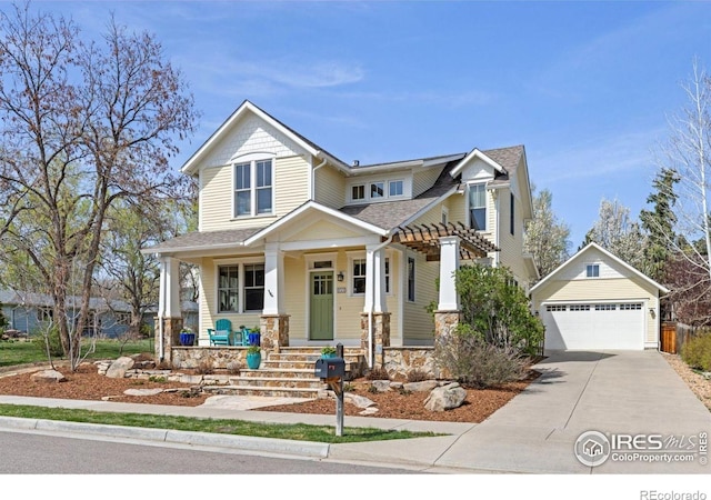 245 Spruce St, Louisville, CO 80027 - craftsman-style home with concrete driveway, stone siding, a porch, an outbuilding, and a garage