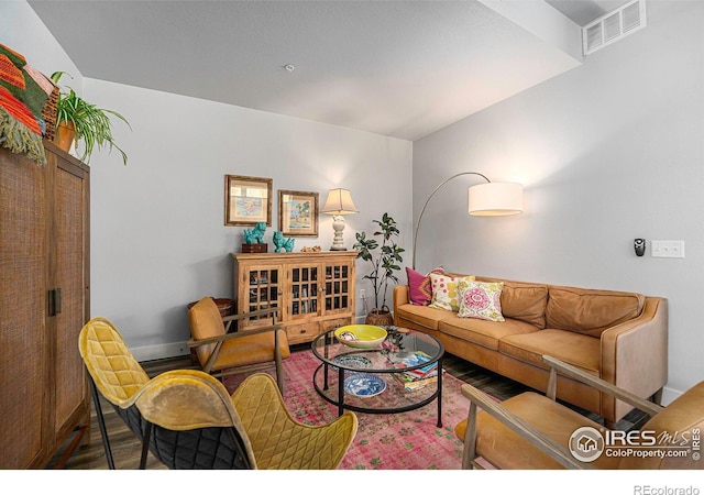 living area with visible vents, baseboards, and wood finished floors