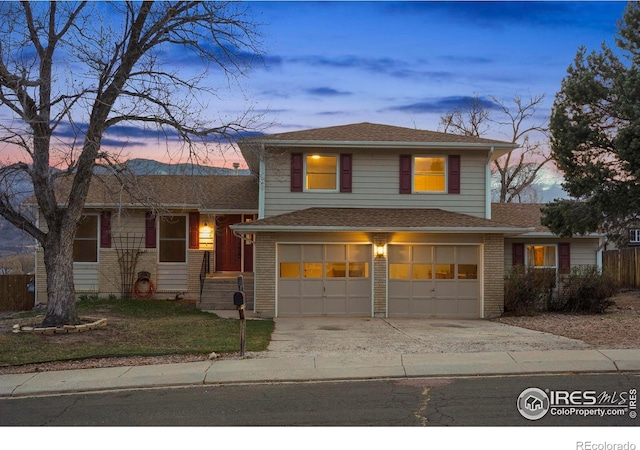 1458 Friendship Ln W, Colorado Springs, CO 80904 - split level home with concrete driveway, brick siding, and an attached garage