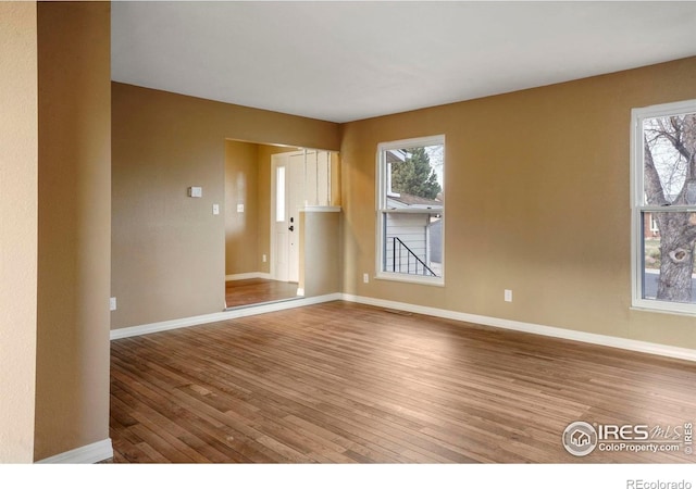 1458 Friendship Ln W, Colorado Springs, CO 80904 - spare room with baseboards, plenty of natural light, and hardwood / wood-style flooring