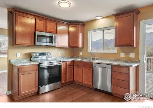 1458 Friendship Ln W, Colorado Springs, CO 80904 - kitchen featuring light countertops, brown cabinets, dark wood finished floors, stainless steel appliances, and a sink