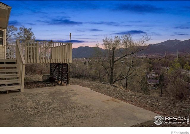 1458 Friendship Ln W, Colorado Springs, CO 80904 - patio terrace at dusk featuring a deck with mountain view and stairs