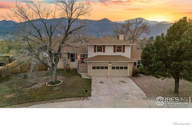 1458 Friendship Ln W, Colorado Springs, CO 80904 - view of front facade with a mountain view, a chimney, concrete driveway, and a garage