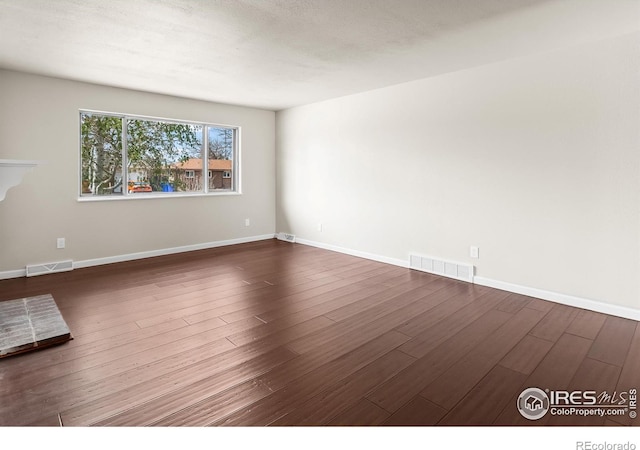422 38th Ave, Greeley, CO 80634 - unfurnished room with baseboards, dark wood finished floors, and visible vents