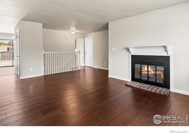 422 38th Ave, Greeley, CO 80634 - unfurnished living room featuring wood-type flooring, baseboards, and a glass covered fireplace