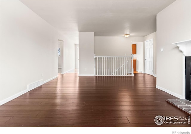 422 38th Ave, Greeley, CO 80634 - unfurnished living room with dark wood-style flooring, baseboards, and visible vents