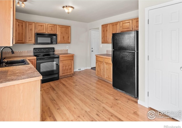 422 38th Ave, Greeley, CO 80634 - kitchen with a sink, light wood-style flooring, black appliances, and light countertops