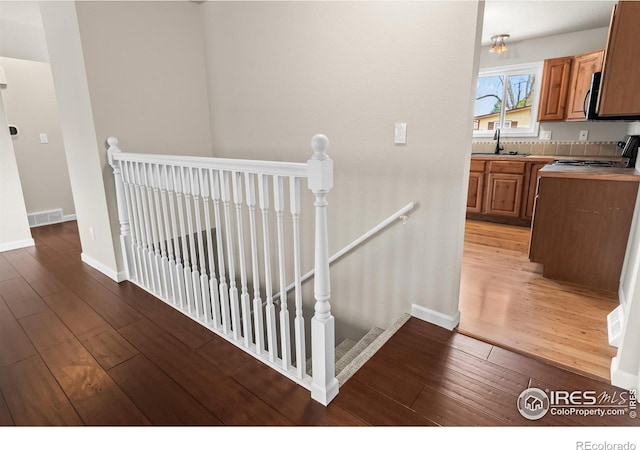 422 38th Ave, Greeley, CO 80634 - staircase with baseboards, wood-type flooring, and visible vents