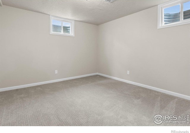 422 38th Ave, Greeley, CO 80634 - basement featuring baseboards, carpet flooring, a textured ceiling, and plenty of natural light