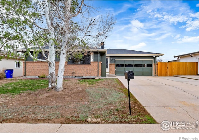 422 38th Ave, Greeley, CO 80634 - split level home with brick siding, driveway, fence, and a garage