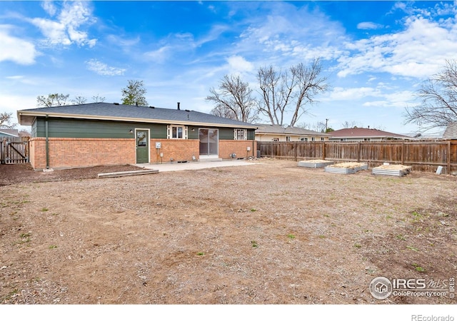 422 38th Ave, Greeley, CO 80634 - back of house with brick siding, a fenced backyard, and a patio area