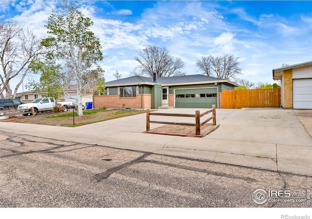 422 38th Ave, Greeley, CO 80634 - ranch-style house with fence, concrete driveway, brick siding, and a garage