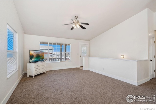 spare room featuring carpet floors, baseboards, a ceiling fan, and vaulted ceiling