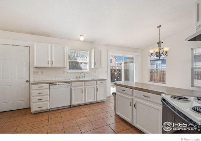 kitchen with a sink, white appliances, plenty of natural light, and a notable chandelier