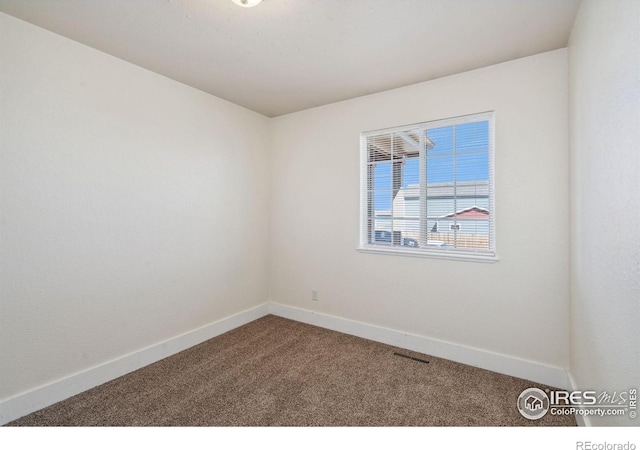 spare room with baseboards, visible vents, and carpet floors