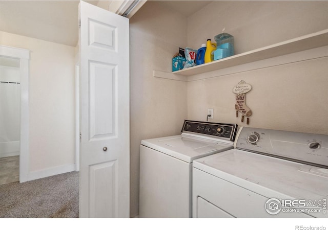 clothes washing area featuring carpet flooring, baseboards, washing machine and dryer, and laundry area