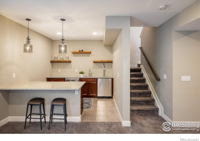 16392 Spanish Peak Way, Broomfield, CO 80023 - kitchen with light carpet, a breakfast bar area, a peninsula, a sink, and dishwasher
