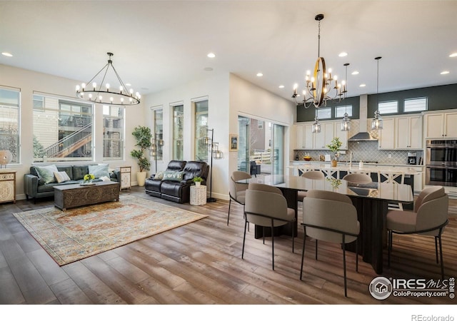 16392 Spanish Peak Way, Broomfield, CO 80023 - dining room featuring a chandelier, recessed lighting, wood finished floors, and baseboards