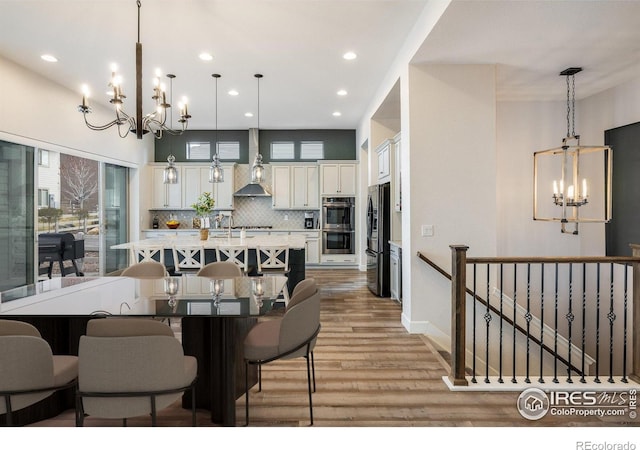 16392 Spanish Peak Way, Broomfield, CO 80023 - dining space with a chandelier, light wood-style flooring, recessed lighting, and baseboards