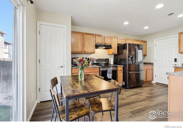 10433 Forester Pl, Longmont, CO 80504 - kitchen with dark wood finished floors, under cabinet range hood, recessed lighting, light brown cabinetry, and appliances with stainless steel finishes
