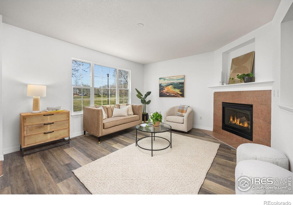 406 N Parkside Dr Unit C, Longmont, CO 80501 - living area featuring dark wood finished floors, baseboards, and a fireplace