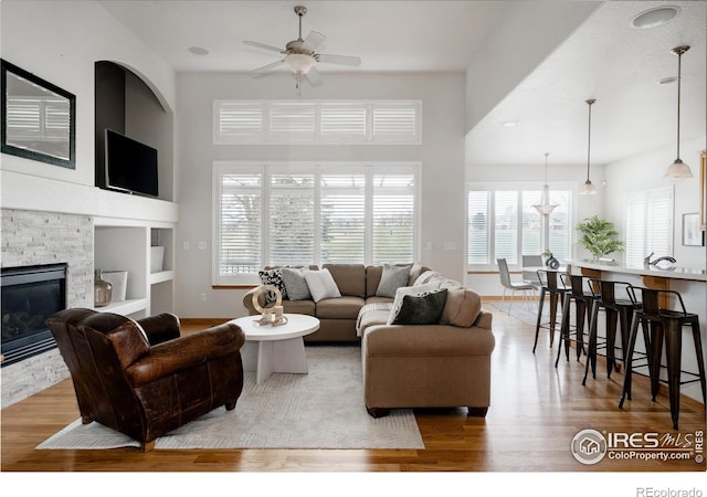 6771 Crooked Stick Dr, Windsor, CO 80550 - living room with light wood finished floors, a ceiling fan, and baseboards