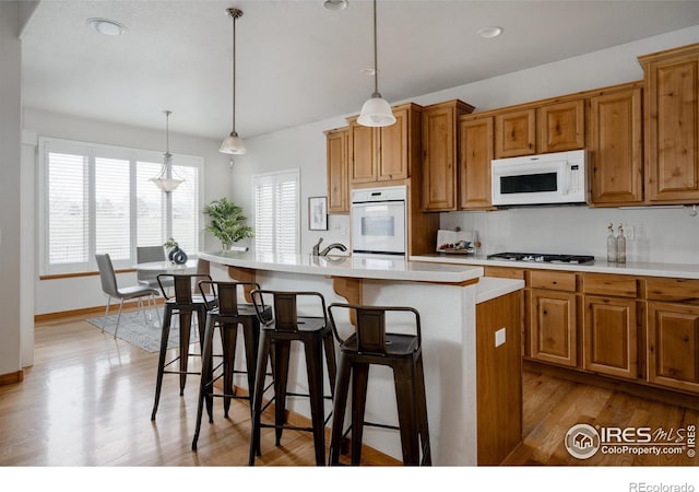 6771 Crooked Stick Dr, Windsor, CO 80550 - kitchen with white appliances, healthy amount of natural light, light wood-style flooring, light countertops, and recessed lighting