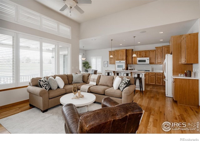 6771 Crooked Stick Dr, Windsor, CO 80550 - living area with ceiling fan, light wood finished floors, a towering ceiling, and recessed lighting