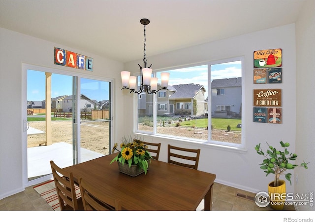 8606 8th St, Greeley, CO 80634 - dining space featuring a residential view, visible vents, baseboards, and a chandelier