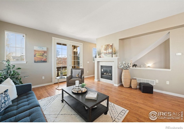 658 Casper Dr, Lafayette, CO 80026 - living area featuring wood finished floors, healthy amount of natural light, a tiled fireplace, and baseboards