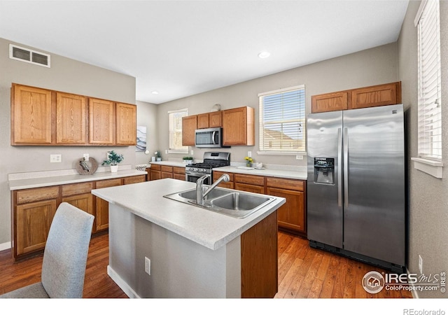 658 Casper Dr, Lafayette, CO 80026 - kitchen featuring appliances with stainless steel finishes, a sink, wood finished floors, light countertops, and recessed lighting