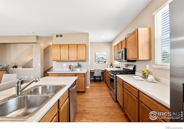 658 Casper Dr, Lafayette, CO 80026 - kitchen with appliances with stainless steel finishes, a sink, light wood finished floors, light countertops, and recessed lighting